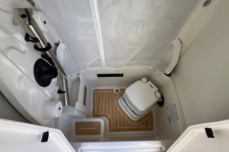 Slide: The Image of 2026 Sailfish 252 boat interior with compact toilet and storage area. - 24