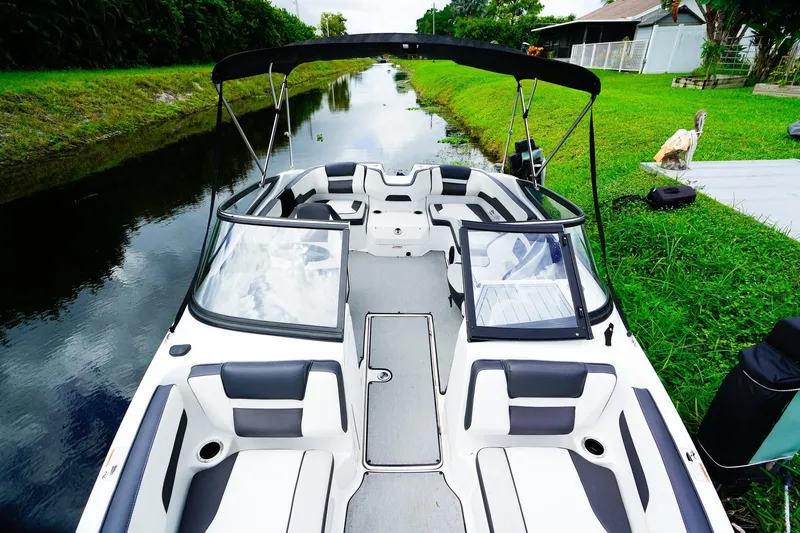 Slide: The Image of 2023 Yamaha Boats SX195 on a serene canal, showcasing sleek interior and modern design. - 15
