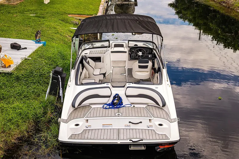 Slide: The Image of 2023 Yamaha Boats SX195 docked on a calm river, featuring sleek interior design. - 23