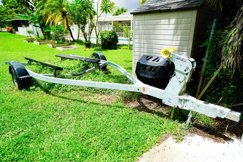 Slide: The Image of Boat trailer for 2023 Yamaha Boats SX195 on grassy lawn near shed. - 26
