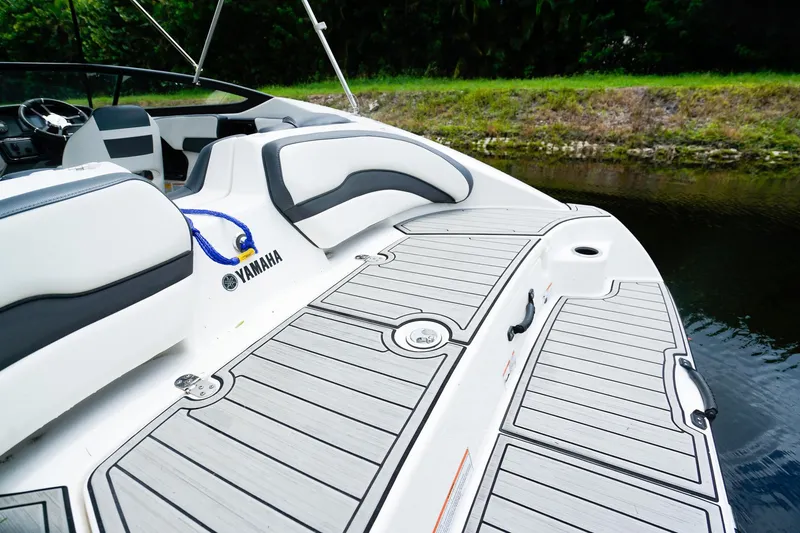 Slide: The Image of 2023 Yamaha Boats SX195 interior with sleek seating and modern design by the water. - 4