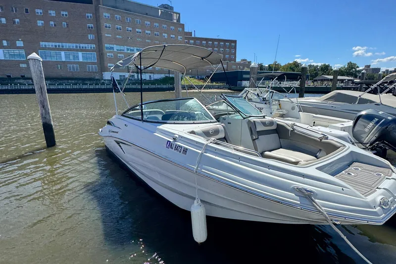 Slide: The Image of 2022 Crownline Eclipse E235 XS boat docked in a marina, sunny day. - 1