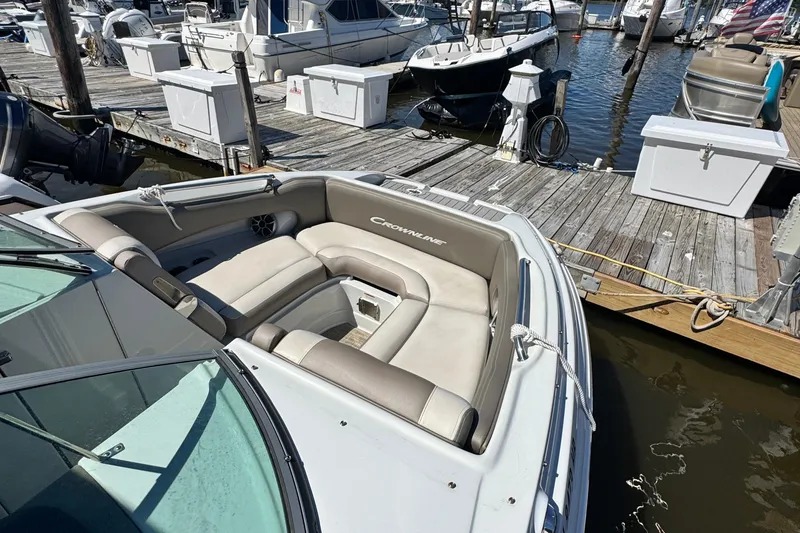 Slide: The Image of 2022 Crownline Eclipse E235 XS boat docked at marina with cushioned seating. - 14