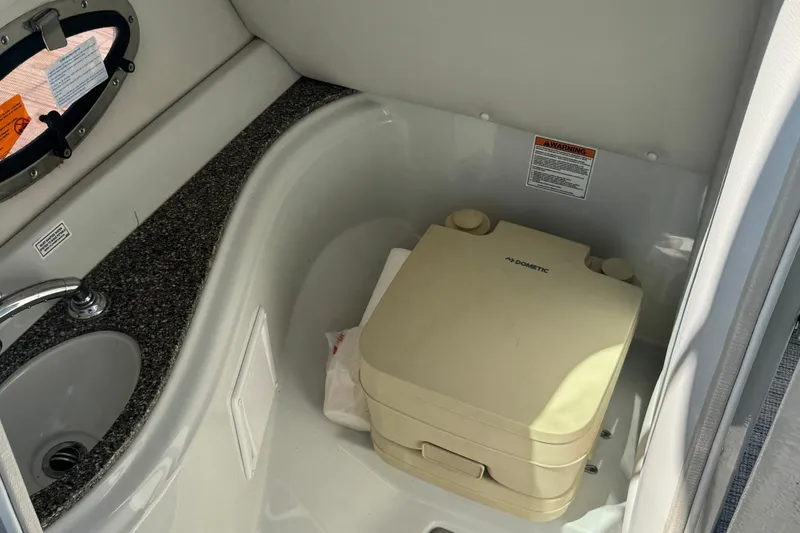 Slide: The Image of 2022 Crownline Eclipse E235 XS boat interior with sink and portable toilet. - 16