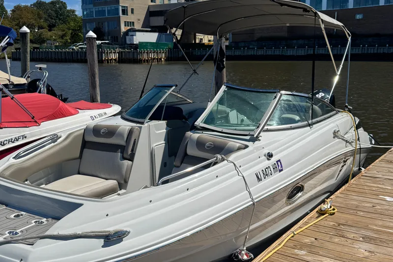 Slide: The Image of 2022 Crownline Eclipse E235 XS boat docked by the waterfront. - 2