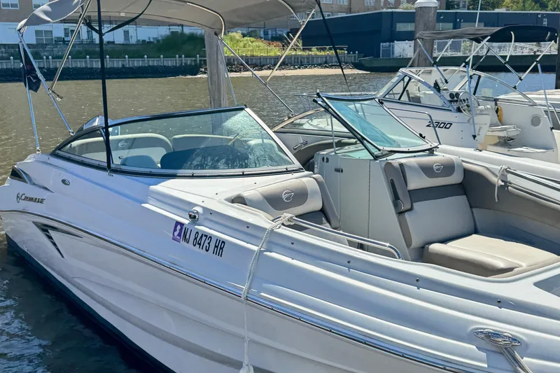 Slide: The Image of 2022 Crownline Eclipse E235 XS boat docked in a marina, featuring sleek design and comfortable seating. - 5