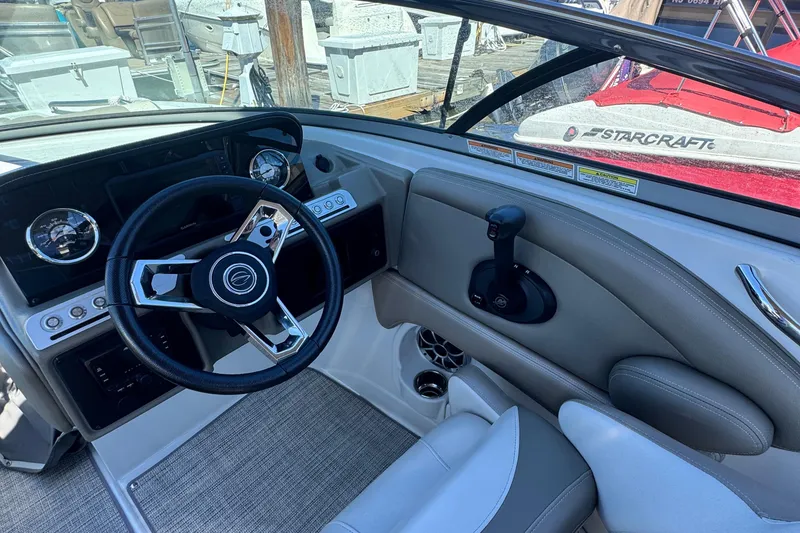 Slide: The Image of 2022 Crownline Eclipse E235 XS boat cockpit with steering wheel and controls. - 6