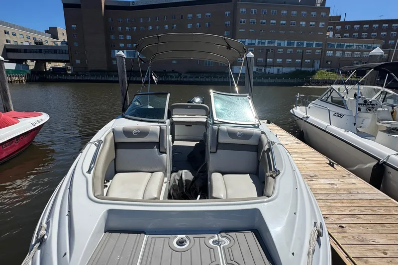 Slide: The Image of 2022 Crownline Eclipse E235 XS boat docked, featuring spacious seating and sleek design. - 7