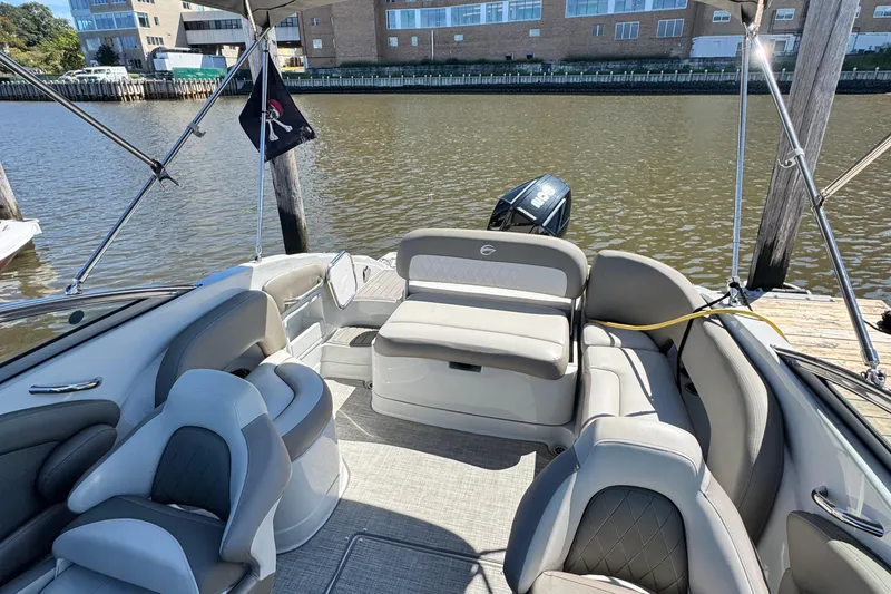 Slide: The Image of 2022 Crownline Eclipse E235 XS boat interior with seating, docked by the water. - 8