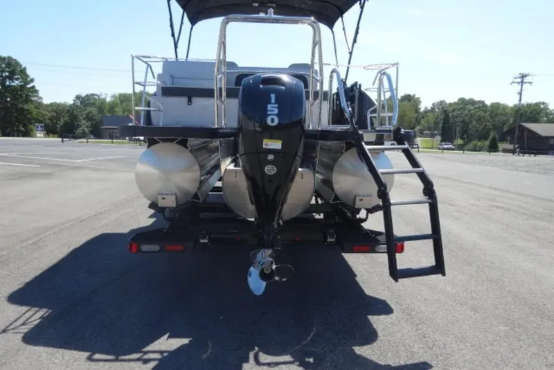 Slide: The Image of 2026 Harris Cruiser 230 Heritage pontoon boat with 150 HP engine, rear view. - 6