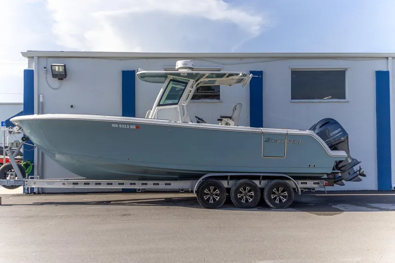 The Image of 2022 Sailfish 272 CC boat on trailer, parked outside a building. - 0