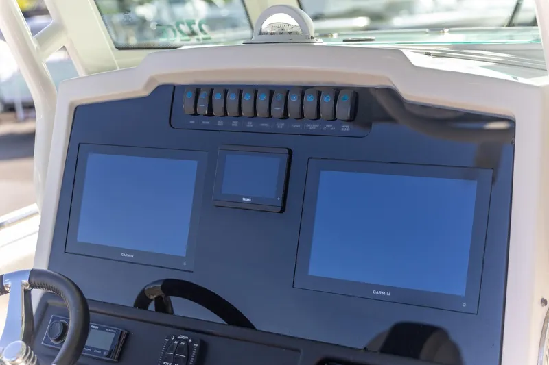 Slide: The Image of 2022 Sailfish 272 CC boat with dual 200 HP outboard engines, parked outdoors. - 5