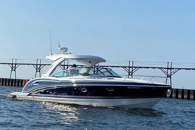 The Image of 2021 Formula 350 Sun Sport boat cruising on water near a pier. - 0