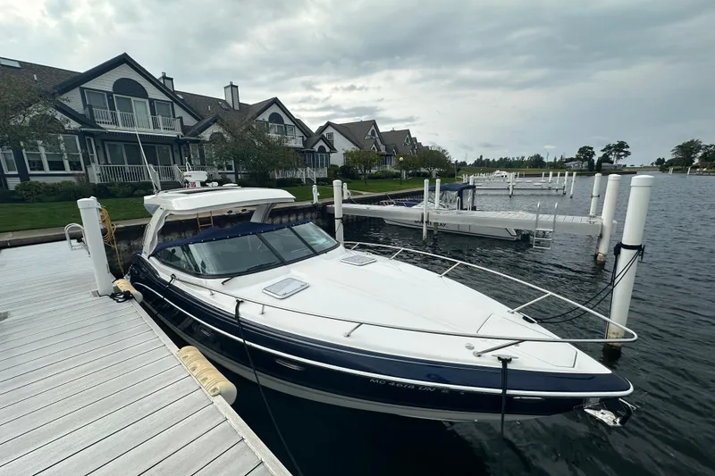 Slide: The Image of 2021 Formula 350 Sun Sport docked by waterfront homes under cloudy skies. - 3