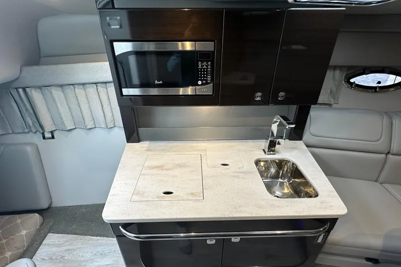 Slide: The Image of 2021 Formula 350 Sun Sport interior kitchen with microwave, sink, and modern cabinetry. - 31