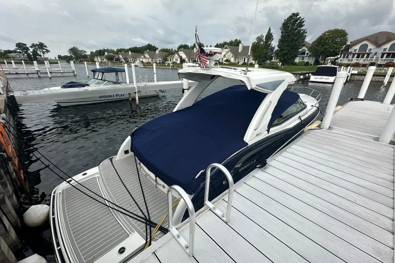 Slide: The Image of 2021 Formula 350 Sun Sport docked at marina with cover, surrounded by boats and waterfront homes. - 4