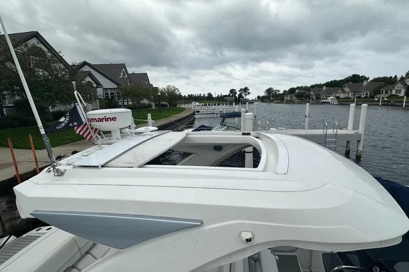 Slide: The Image of 2021 Formula 350 Sun Sport boat docked by waterfront homes under cloudy skies. - 73