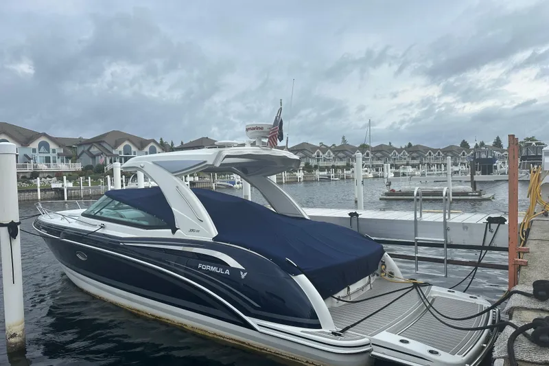 Slide: The Image of 2021 Formula 350 Sun Sport boat docked at a marina under cloudy skies. - 9