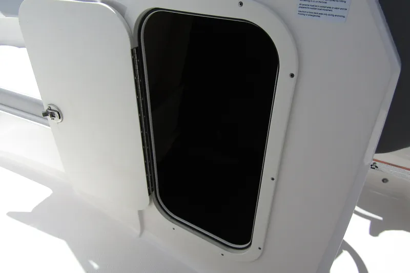Slide: The Image of 2022 Chaparral 23 SSi boat storage compartment with open white door. - 13