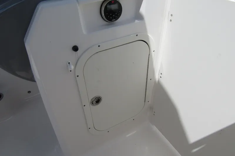 Slide: The Image of 2022 Chaparral 23 SSi boat interior with storage compartment and gauge. - 14