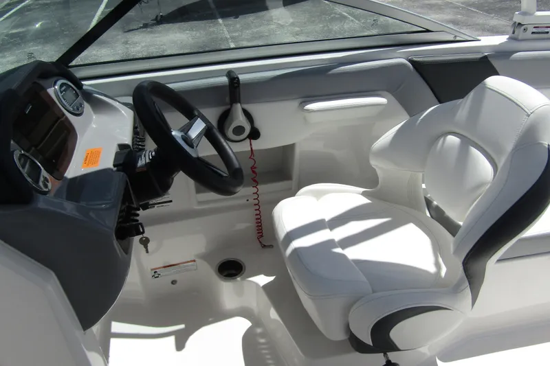 Slide: The Image of 2022 Chaparral 23 SSi boat interior with steering wheel and white captain's seat. - 16