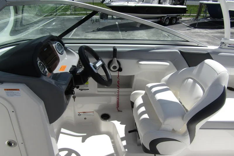 Slide: The Image of 2022 Chaparral 23 SSi boat interior with steering wheel and white seating. - 17