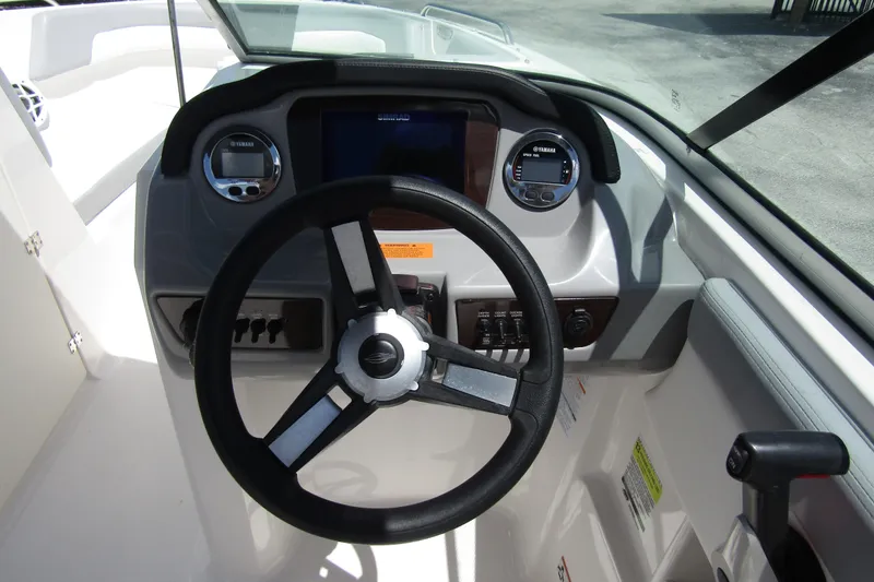 Slide: The Image of 2022 Chaparral 23 SSi boat dashboard with steering wheel and Yamaha controls. - 18
