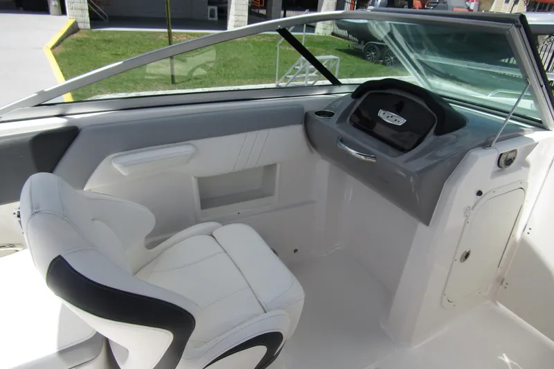 Slide: The Image of 2022 Chaparral 23 SSi boat interior with white seating and sleek dashboard design. - 22