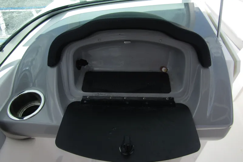 Slide: The Image of 2022 Chaparral 23 SSi boat dashboard storage compartment with cup holder. - 24