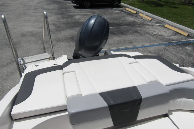 Slide: The Image of 2022 Chaparral 23 SSi boat with sleek seating and outboard motor in parking lot. - 28