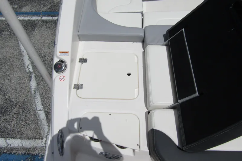 Slide: The Image of 2022 Chaparral 23 SSi boat interior with white seating and storage compartment. - 31