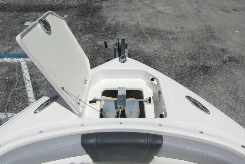 Slide: The Image of 2022 Chaparral 23 SSi boat anchor compartment with open hatch, showing anchor storage. - 7