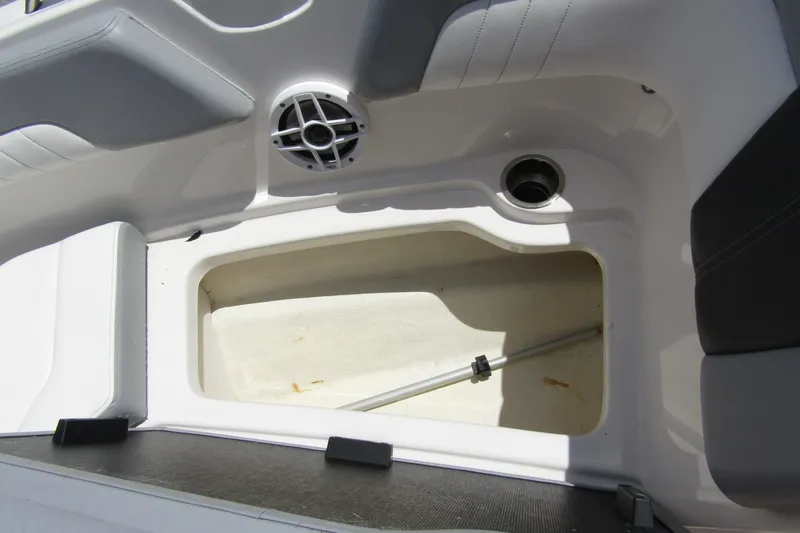 Slide: The Image of 2022 Chaparral 23 SSi boat storage compartment with speaker and drain. - 9