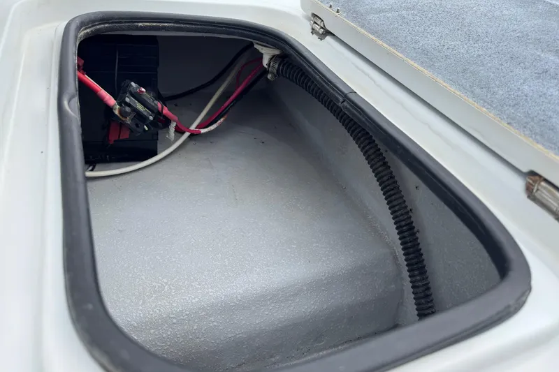 Slide: The Image of Open storage compartment in 2006 Majek 22 Extreme boat, showing wiring and battery. - 16