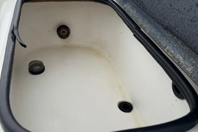 Slide: The Image of Livewell compartment in a 2006 Majek 22 Extreme boat, featuring drainage and mesh filters. - 18