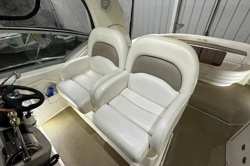 Slide: The Image of 2004 Sea Ray 340 Sundancer cockpit with dual white leather seats and steering wheel. - 16