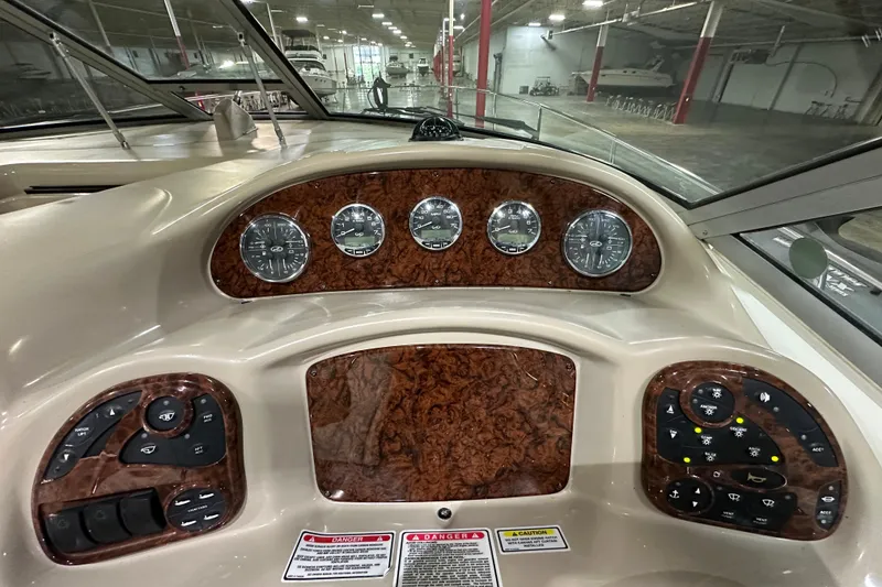 Slide: The Image of Dashboard of a 2004 Sea Ray 340 Sundancer boat with wood grain finish and gauges. - 19