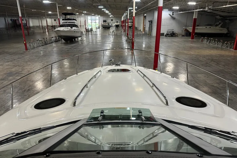 Slide: The Image of 2004 Sea Ray 340 Sundancer in a spacious indoor showroom with other boats. - 25