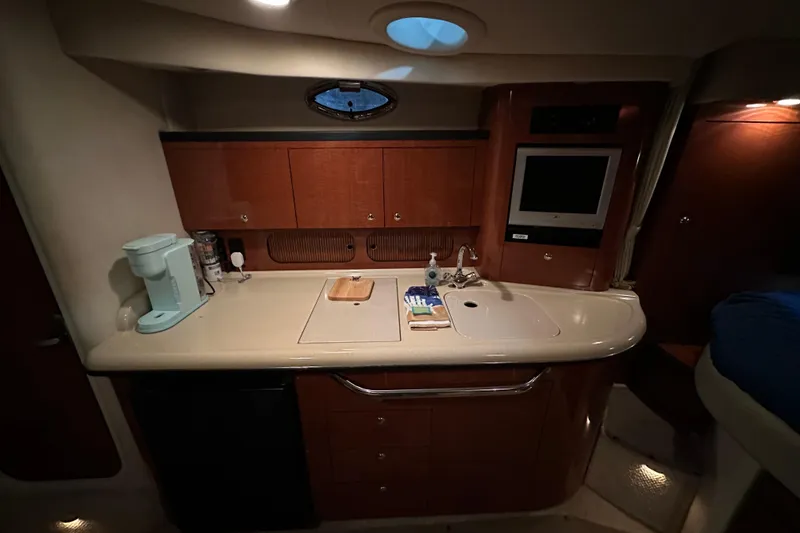 Slide: The Image of 2004 Sea Ray 340 Sundancer cabin kitchen with sink, cabinets, and appliances. - 32