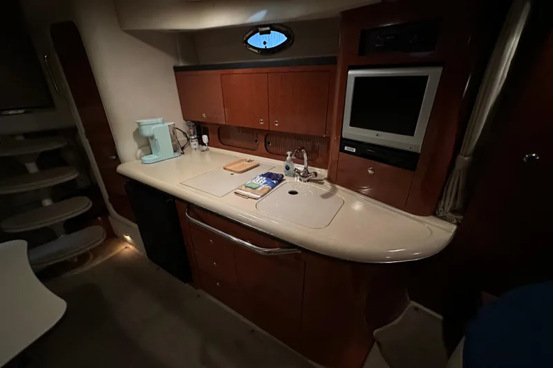 Slide: The Image of 2004 Sea Ray 340 Sundancer interior with kitchenette, sink, and TV. - 33