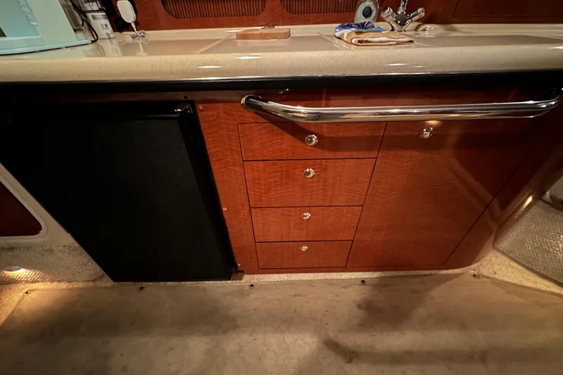 Slide: The Image of 2004 Sea Ray 340 Sundancer interior kitchen with wood cabinetry and countertop. - 34