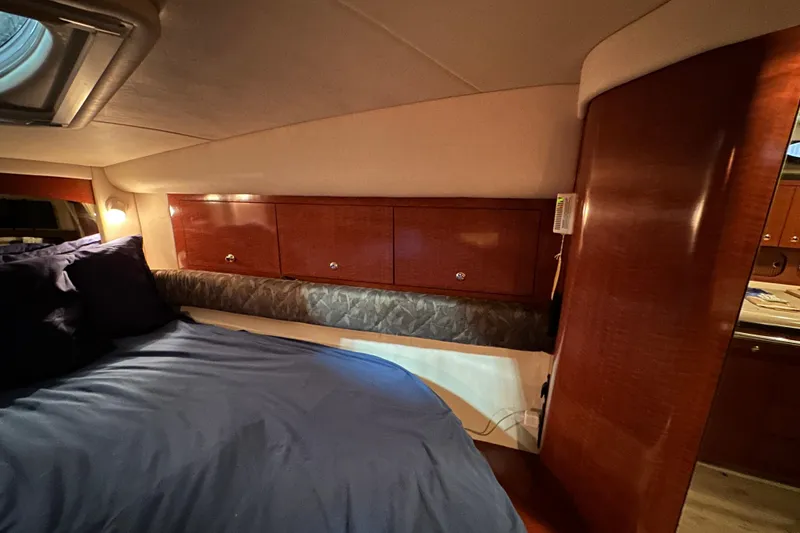 Slide: The Image of Luxurious cabin interior of 2004 Sea Ray 340 Sundancer with wood paneling and cozy bedding. - 41