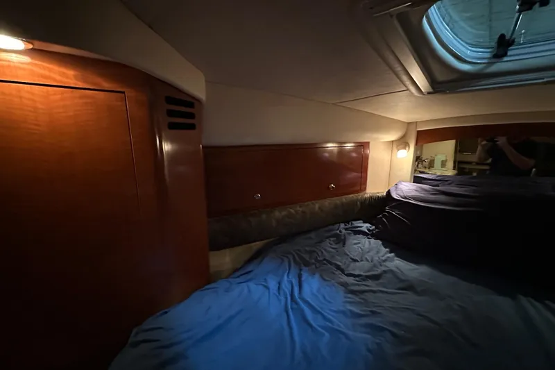 Slide: The Image of Interior cabin of 2004 Sea Ray 340 Sundancer with wood paneling and cozy bedding. - 42