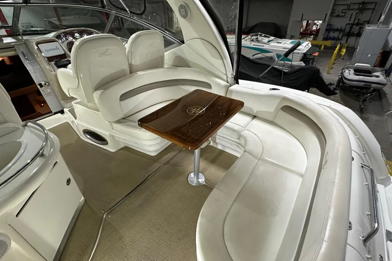 Slide: The Image of 2004 Sea Ray 340 Sundancer interior with white seating and wooden table. - 6