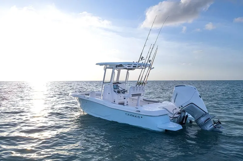 Slide: The Image of 2026 Caymas 24 HB boat on calm ocean at sunset, equipped with fishing rods. - 2