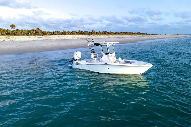 Slide: The Image of 2026 Caymas 24 HB boat anchored near a sandy beach with clear blue water. - 3