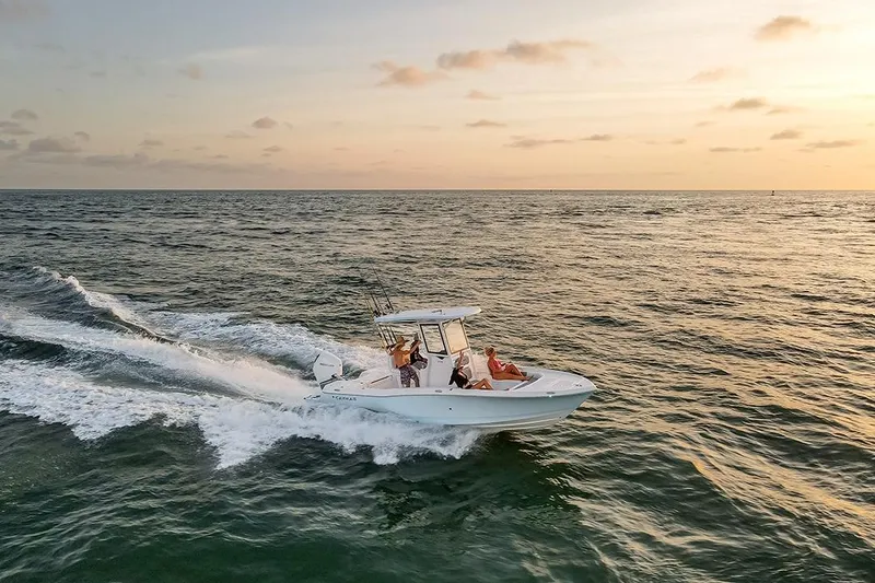 Slide: The Image of 2026 Caymas 24 HB boat cruising on open water at sunset. - 4