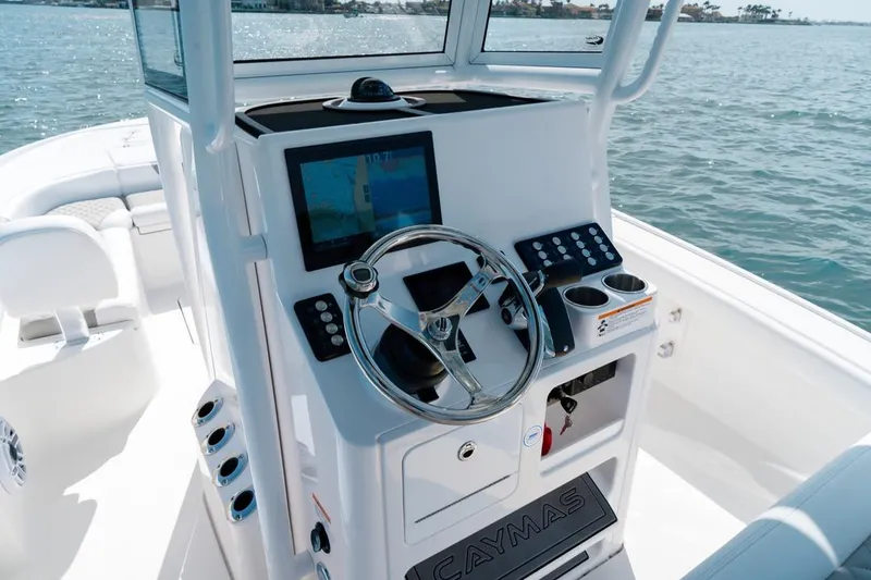 Slide: The Image of 2026 Caymas 24 HB boat console with steering wheel and navigation display on water. - 5