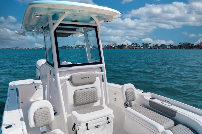 Slide: The Image of 2026 Caymas 24 HB boat on blue water, featuring sleek design and comfortable seating. - 7