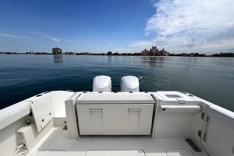 Slide: The Image of 2020 Pursuit S 328 Sport boat on calm water with scenic coastal view. - 10